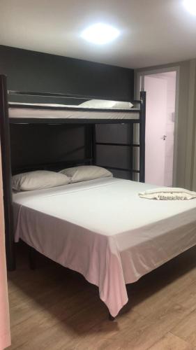 a bedroom with a bunk bed with a white mattress at Aiezza Hotel in Barcarena