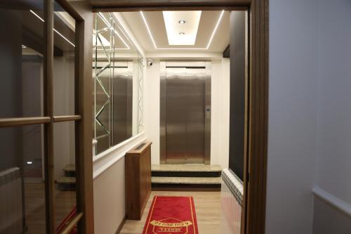 a hallway with a red rug on the floor at Agušević Home in Novi Pazar