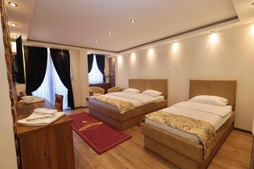 a hotel room with two beds and a television at Agušević Home in Novi Pazar