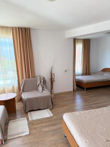 a bedroom with two beds and a table and a window at Hotel Andre in Burgas