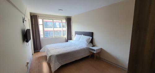 a small bedroom with a bed and a window at Apartamentos San Martín in San Antonio