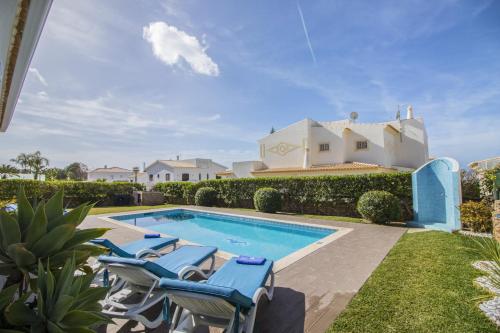 a pool with chairs and a house in the background at Villa Magali by Algarve Holidays in Galé