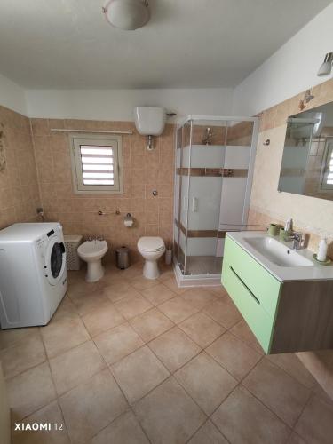 a bathroom with a sink and a toilet and a shower at Mambo House in Sarroch