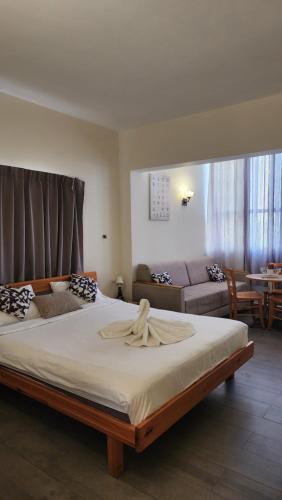a bedroom with a large bed and a couch at David Hameleh House in Netanya