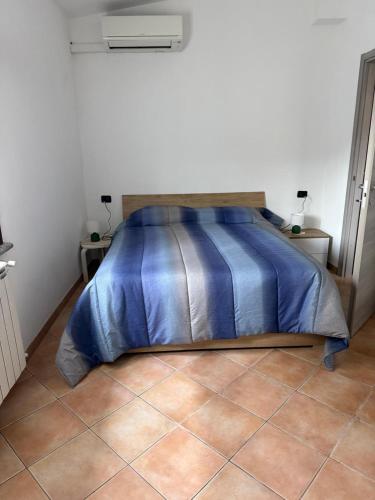 a bed with a blue comforter in a bedroom at Casotta Luca in Vigevano