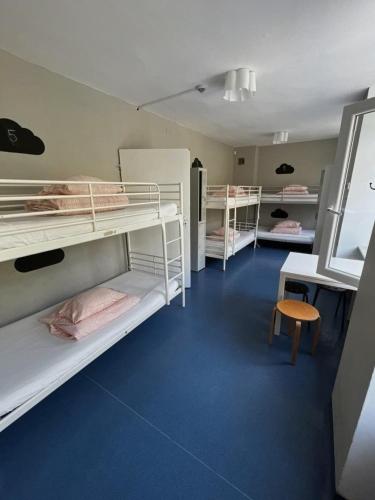 a room with three bunk beds and a chair at Bazylika hostel in Warsaw