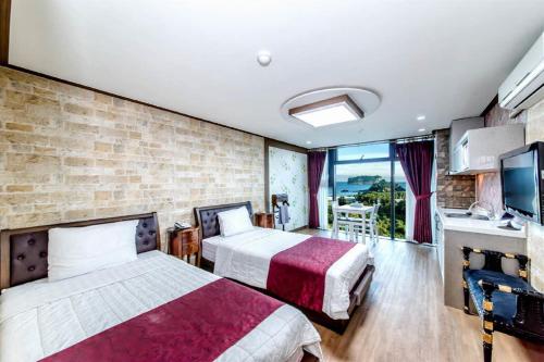 een hotelkamer met 2 bedden en een balkon bij Olleyo Resort in Seogwipo
