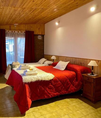 a bedroom with a large red bed in a room at Departamento Quetro in Trevelín