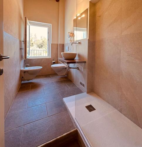 a bathroom with two sinks and two toilets at Relais Le Fornacelle in Castagneto Carducci