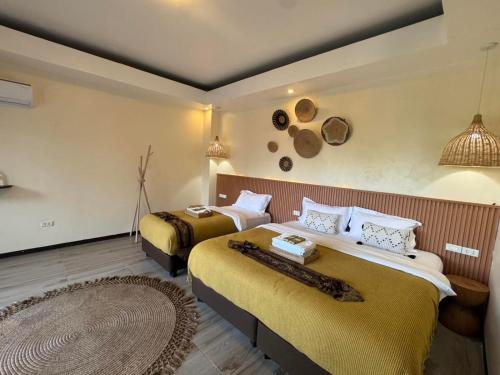 a hotel room with two beds and a rug at Infinity Bay Suites in Puerto Galera