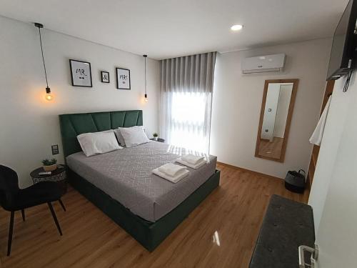 a bedroom with a large bed and a chair at Refúgio D'Aguiar in Aguiar da Beira