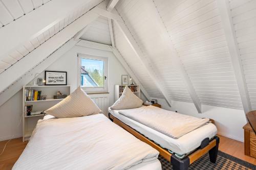 two beds in a attic room with a window at Kleines Schleihaus Lorenz in Boren