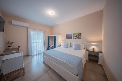 a bedroom with a white bed and a desk at Matiz Igaratá Resort, Spa e Eventos in Igaratá