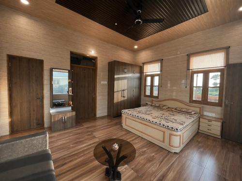 a large bedroom with a large bed and a table at Casa Ramona Luxury Villa With Hot Tub Near Dharamshala Palampur in Pathyar