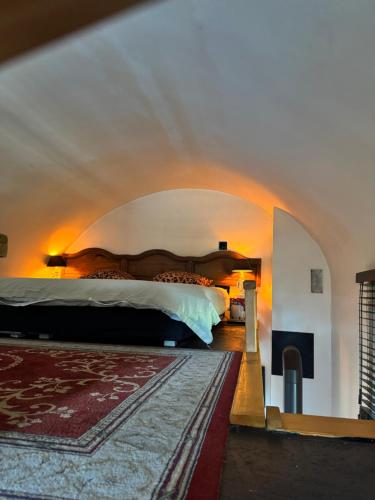 a bedroom with a large bed in an arch way at Le petit Chapitre in Pinterville