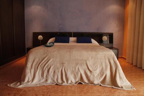 a bedroom with a large bed with blue pillows at Areeta Etxea - Espejo in Espejo