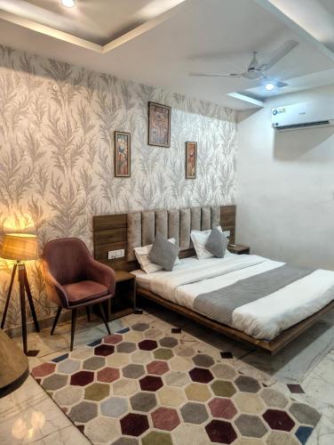 a bedroom with a bed and a chair at Hotel Jairaj in Alwar