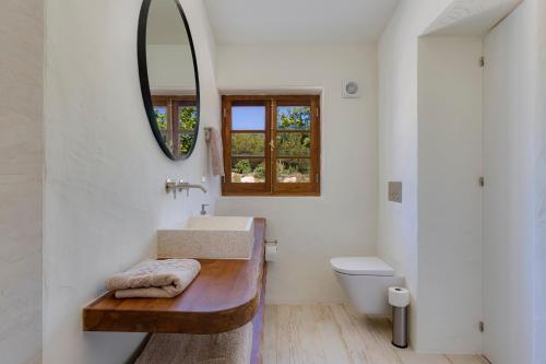 a bathroom with a sink and a mirror and a toilet at Quinta Javali in Aljezur
