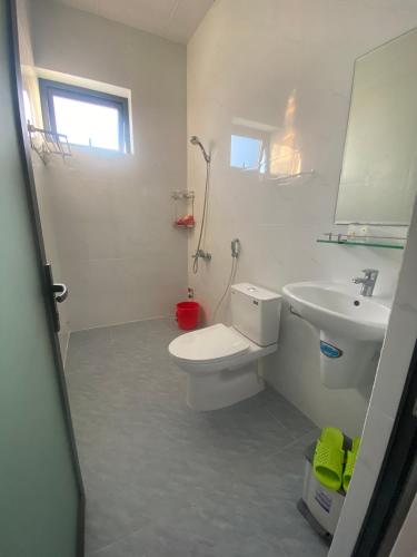 a bathroom with a white toilet and a sink at Nhà Nghỉ THÀNH LỘC in Long Hai