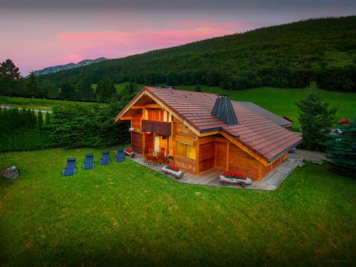a log cabin in the middle of a field at Chalet J'Elage - OVO Network in Saint-Jean-de-Sixt