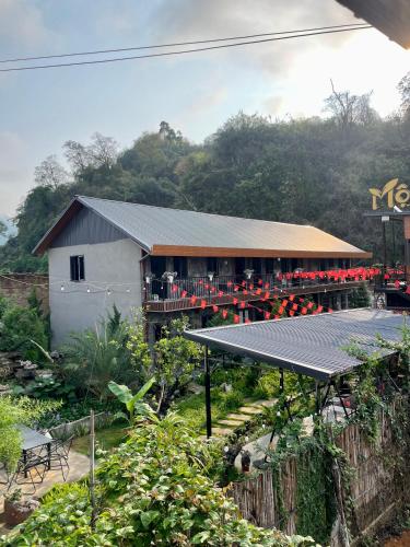 a building with a lot of red flowers in front of it at Mộc Homestay - Mộc Châu in Mộc Châu