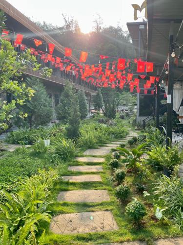 a garden with red flags and a pathway at Mộc Homestay - Mộc Châu in Mộc Châu