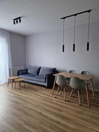 a living room with a blue couch and a table at Apartament Marzeń 13 in Kostrzyn nad Odrą