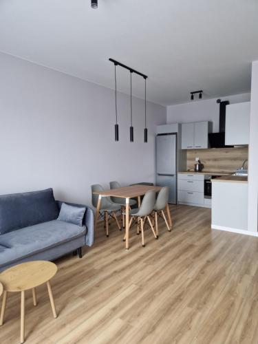 a living room with a blue couch and a table at Apartament Marzeń 13 in Kostrzyn nad Odrą
