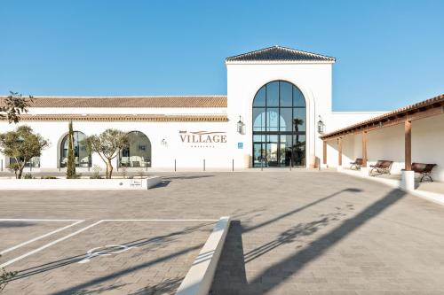 a large white building with a sign that reads village at Hotel Best Village Chipiona in Costa Ballena