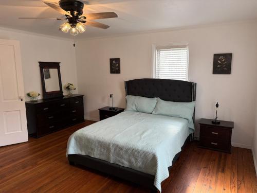 a bedroom with a bed and a ceiling fan at The Sago Palm House in Thomasville