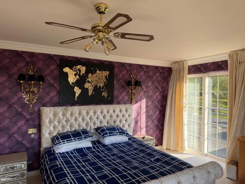a purple bedroom with a bed with a ceiling fan at Winterwood in Listowel