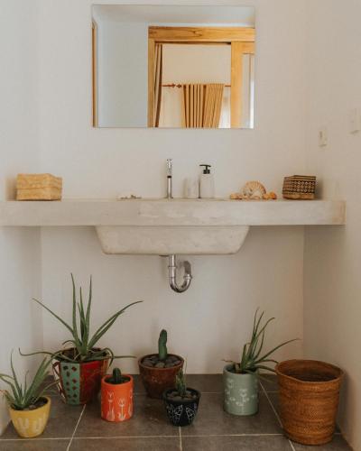 a bathroom with potted plants and a sink at Muara Surf House - Yoyos beachfront in Sekongkang
