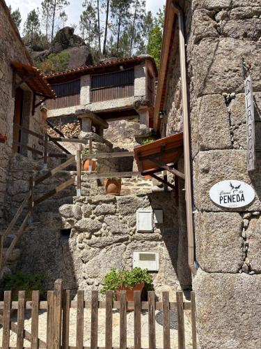 a wooden fence in front of a stone building at Casas da Peneda - Geres in Gavieira