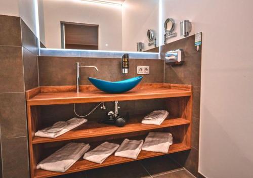 a bathroom with a blue bowl sink and towels at Steinberger Hof in Dietzenbach