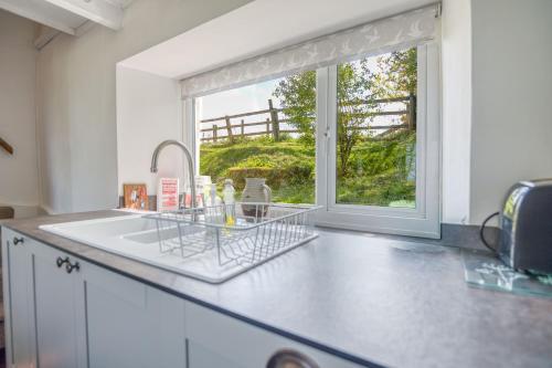a kitchen with a sink and a window at 2 Caerau Isaf in Haverfordwest
