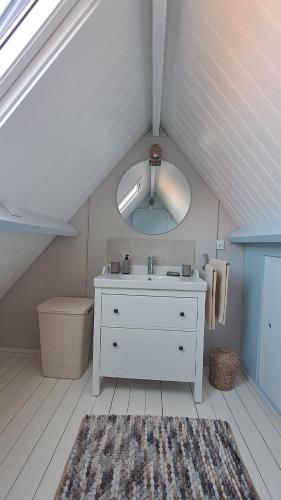 a white bathroom with a sink and a mirror at Camino in Vrouwenpolder