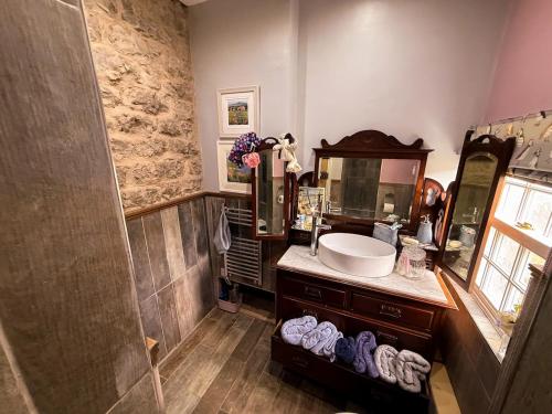 a bathroom with a sink and a mirror at Wingrove Cottage - Sleeps 8 in Morland