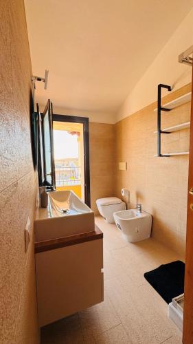 a bathroom with two sinks and two toilets at Aura Apartment in Senorbì