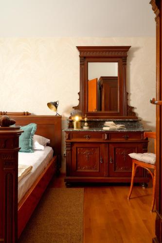 a bedroom with a wooden dresser with a mirror at Heritage House Pjaca, Omiš in Omiš