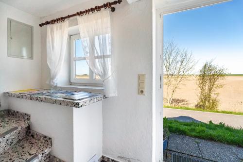 ein Fenster in einem Zimmer mit Blick auf ein Feld in der Unterkunft Schardeichhof Meyer in Pellworm