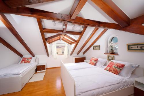 a living room with two white couches and wooden ceilings at Heritage House Pjaca, Omiš in Omiš