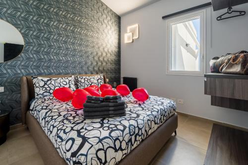 a bedroom with a bed with red pillows on it at Luxury SPA Villa Cefalù in Campofelice di Roccella