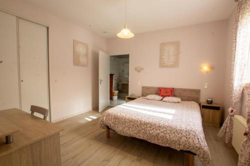 a bedroom with a bed and a table and a room at Gîtes BEAUSOLEIL in Campsegret