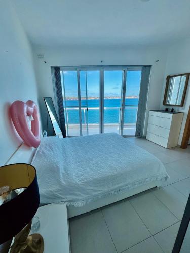 a bedroom with a bed with a view of the ocean at Very nice place by the sea in Is-Sellum