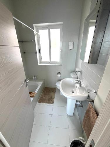 a bathroom with a sink and a toilet and a window at Very nice place by the sea in Is-Sellum