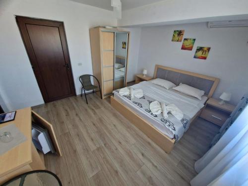 a bedroom with a bed and a wooden floor at Villa Sunset Beach Mamaia Nord in Mamaia Sat/Năvodari