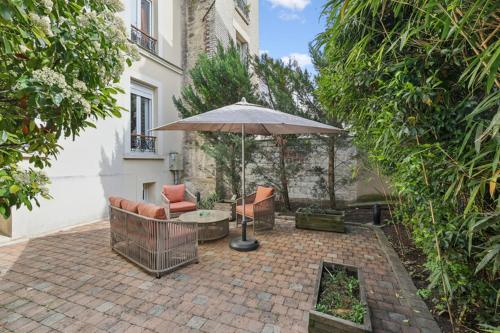 a patio with a table and an umbrella at Loft Fraternité in Bagnolet