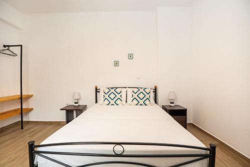 a bed in a room with two night stands and two tables at Anemoessa House in Pera Gyalos