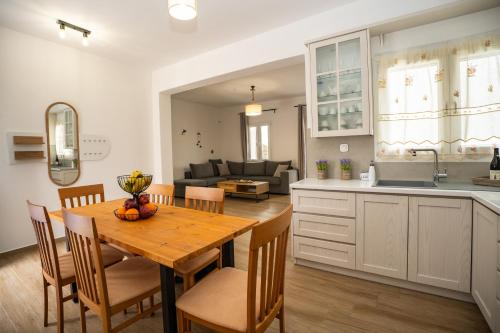 a kitchen and dining room with a wooden table and chairs at Anemoessa House in Pera Gyalos