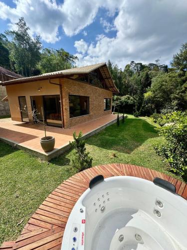 a bath tub in front of a house at Casa com Jacuzzi e Área Gourmet em Mury in Nova Friburgo